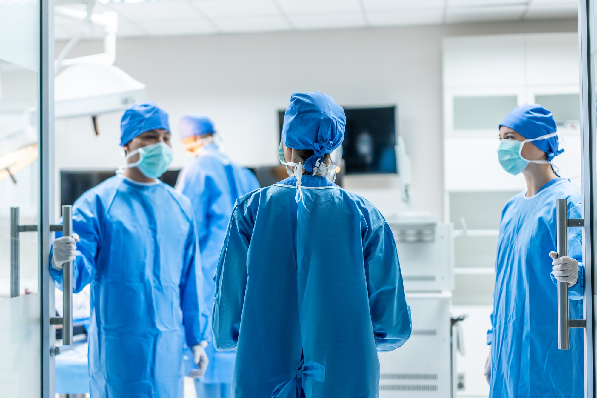 Professional doctors performing surgical operation in operating room.